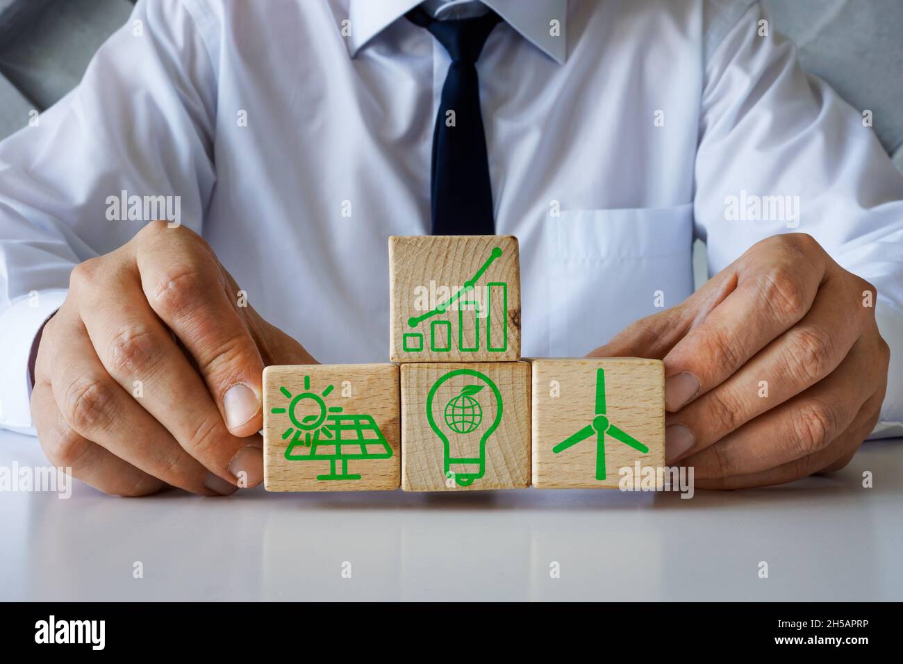 Renewable energy concept. Man holds wooden cubes. Stock Photo