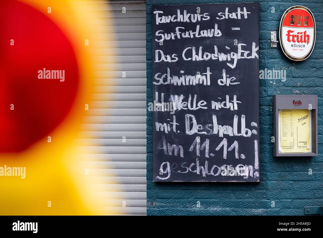 Cologne, Germany. 08th Nov, 2021. "Diving course instead of surfing holiday - The Chlodwig Eck does not swim the 4th wave. Therefore: Closed on 11.11.!" is written on a board in front of the entrance to the Chlodwig Eck pub in Südstadt. Due to the increasing Corona numbers, the city of Cologne wants to tighten the rules for the carnival kick-off on 11.11. once again. Credit: Rolf Vennenbernd/dpa/Alamy Live News Stock Photo