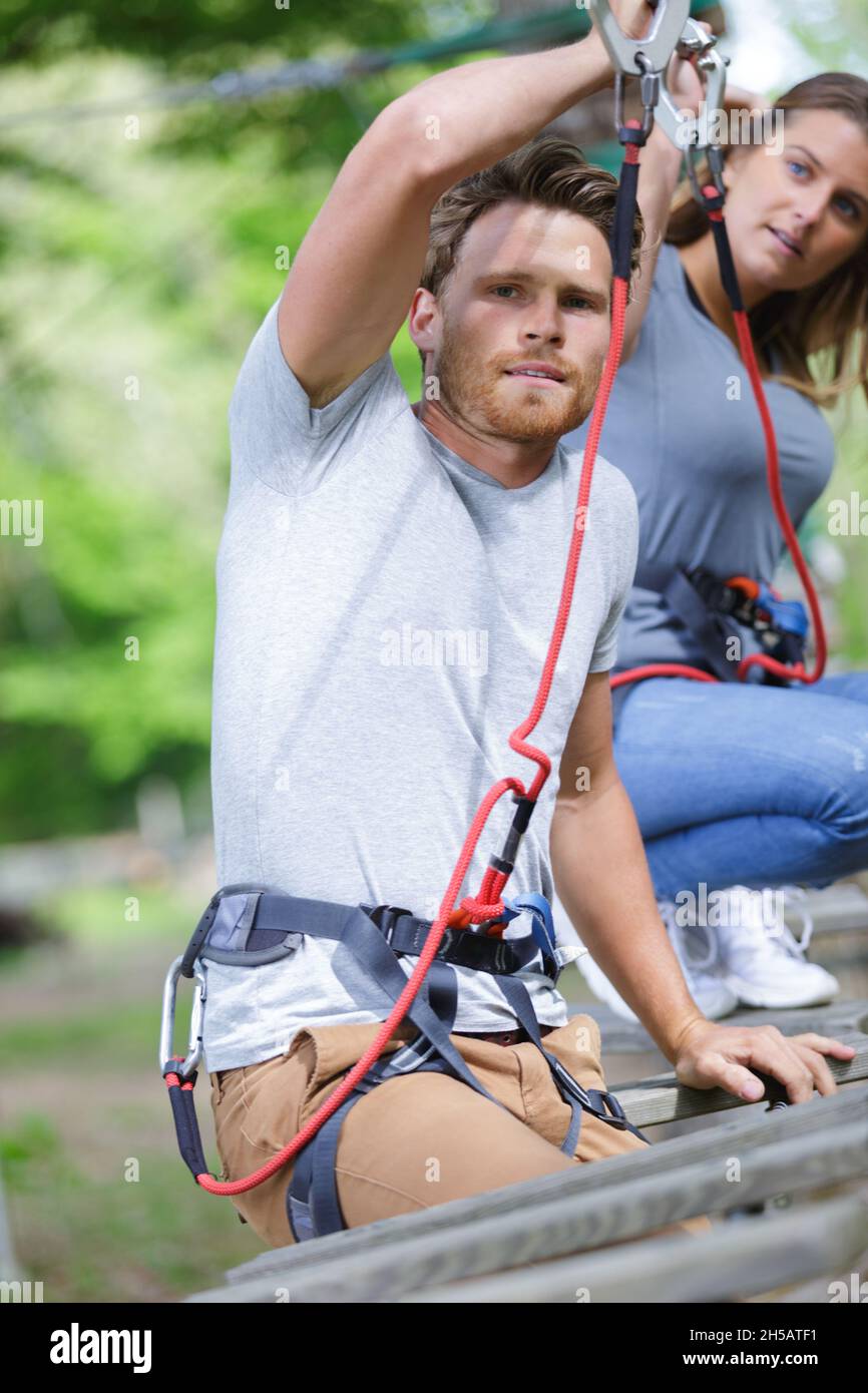 people in safety equipment on a rope park Stock Photo - Alamy