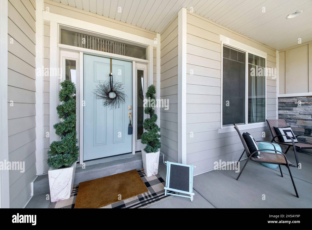 Front porch exterior with light gray vinyl wood siding and mint green