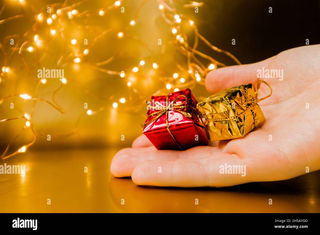 New Year's gift in hand. Presenting a New Year's gift. Small souvenirs. Stock Photo