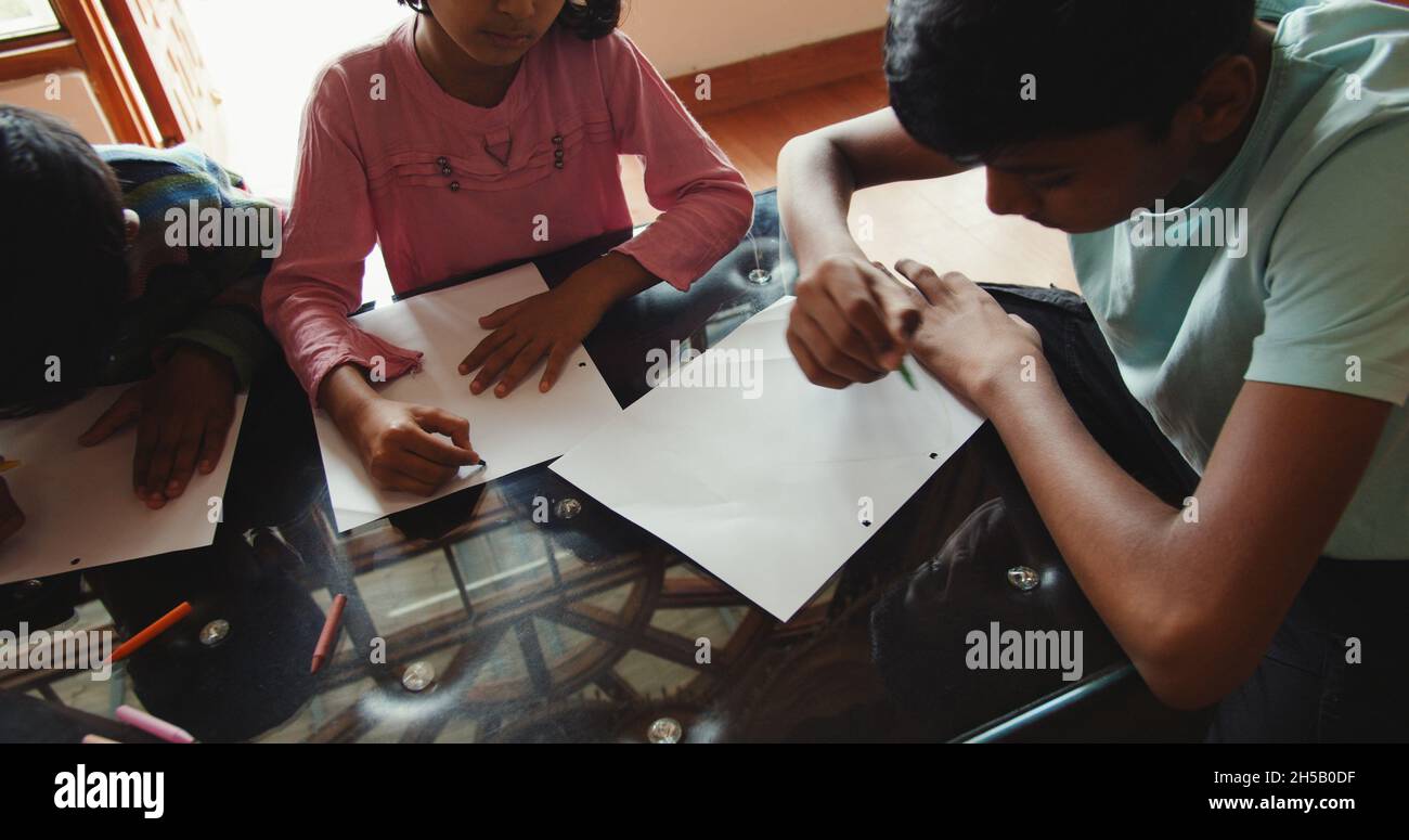 Group of south Asian kids drawing with colorful pencils Stock Photo - Alamy