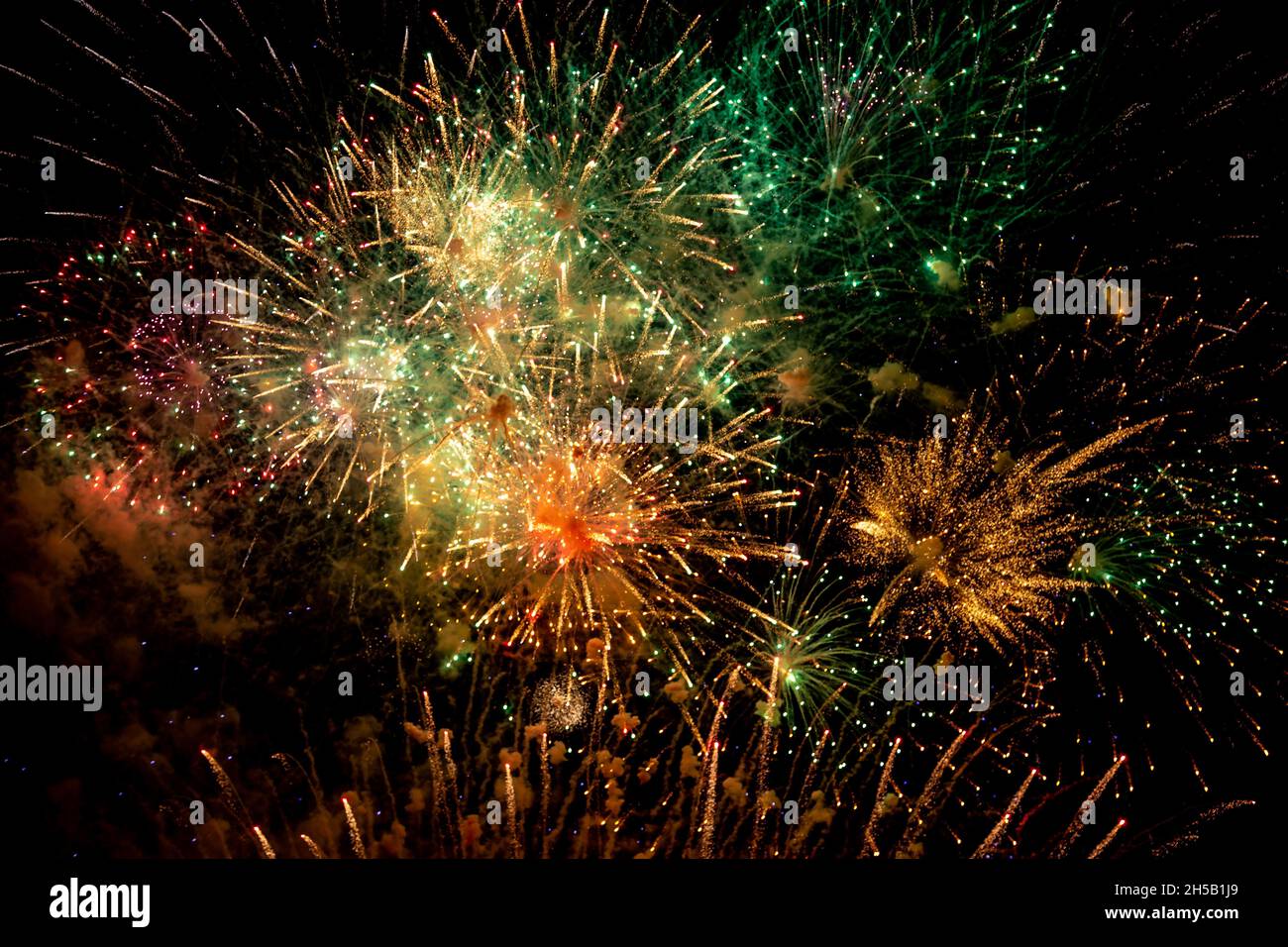 Looking up at fireworks against a night sky Stock Photo