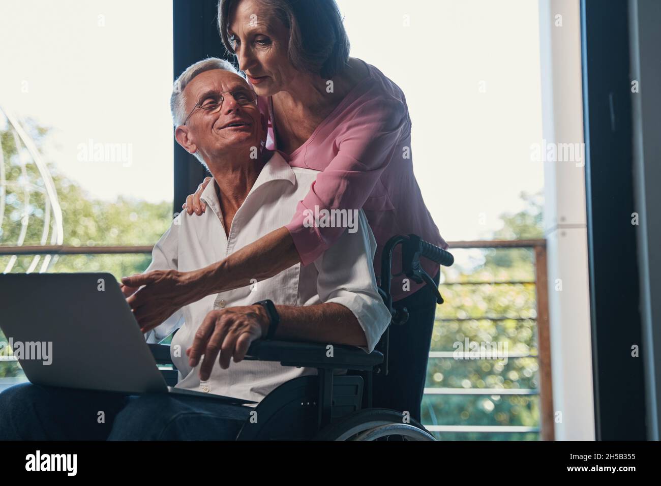 Senior male with disability turning to his wife behind him Stock Photo
