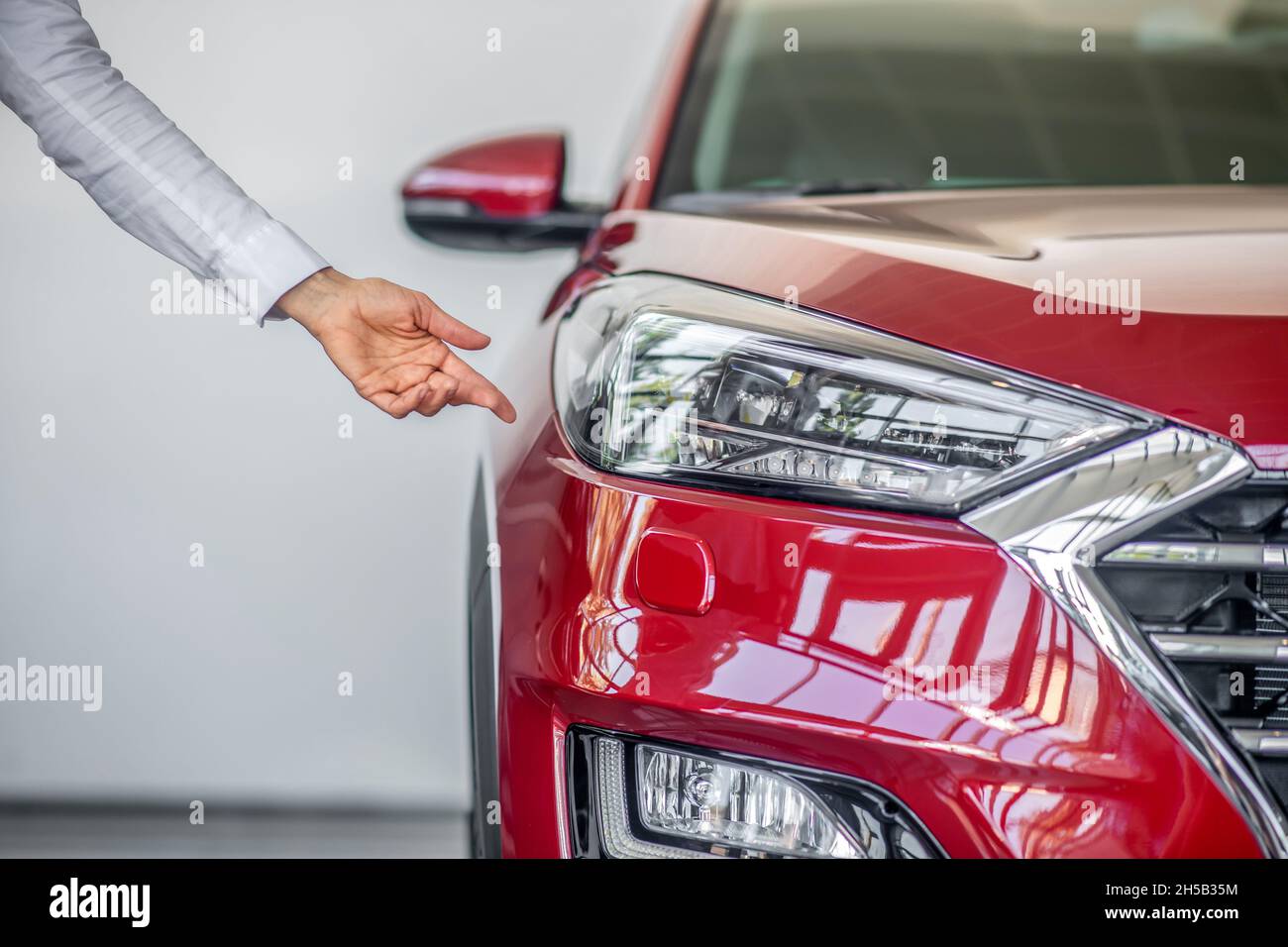 Womans hand pointing to headlight of car Stock Photo