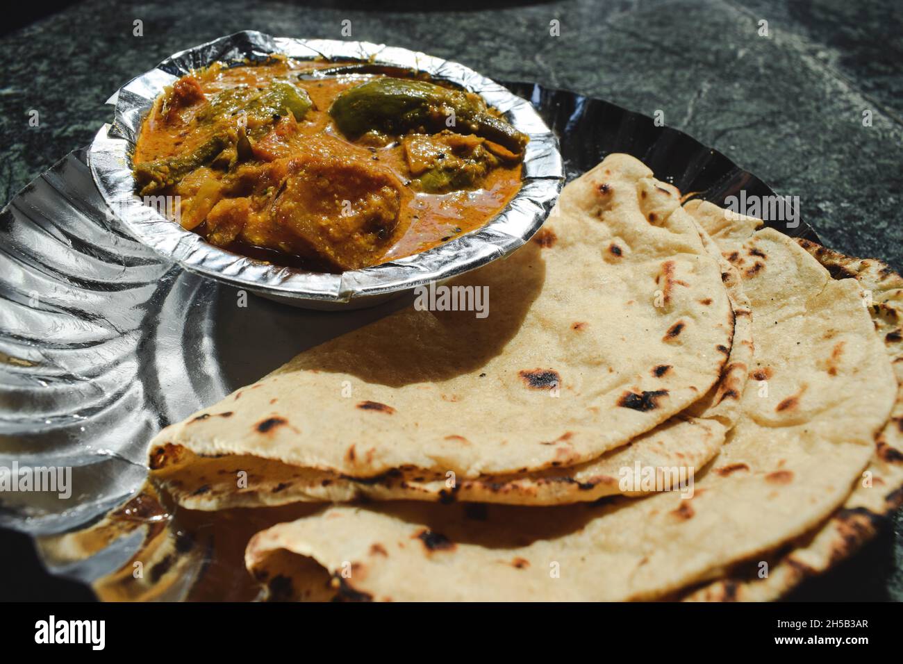 Indian home cooked dhaba style simple and traditional food Roti sabzi. Phulka with potato brinjal curry. Stock Photo