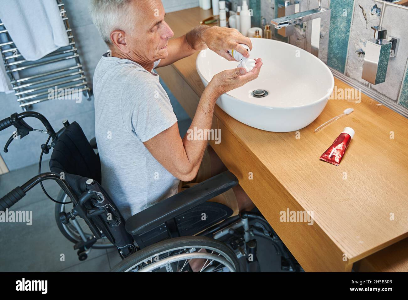 Male with disability pouring shaving cream on his palm Stock Photo