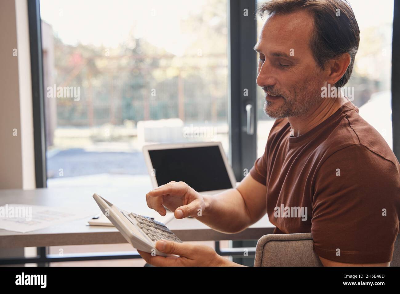 Mature businessman using calculator hi-res stock photography and images ...