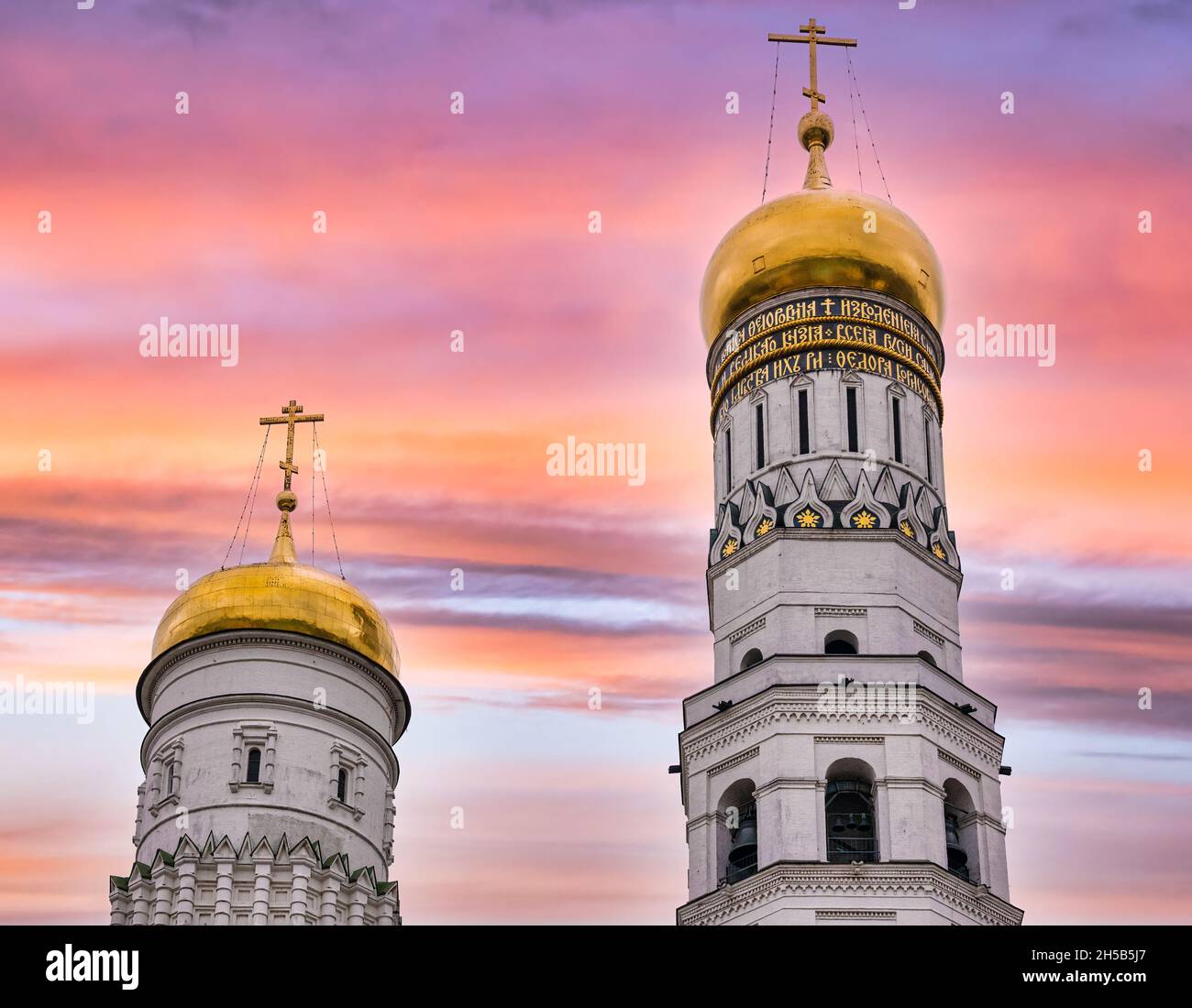Gold onion domes of Ivan the Great Bell Tower & Dormition or Assumption Cathedral with colourful sky at sunset, Kremlin, Moscow, Russia Stock Photo