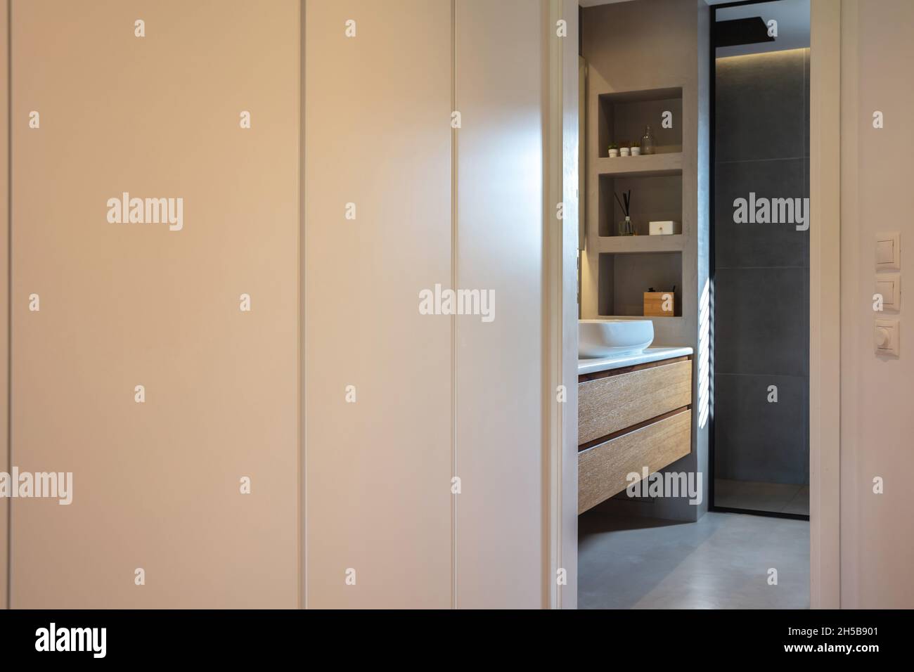 Bedroom wardrobe and bathroom, modern interior design. White clothing