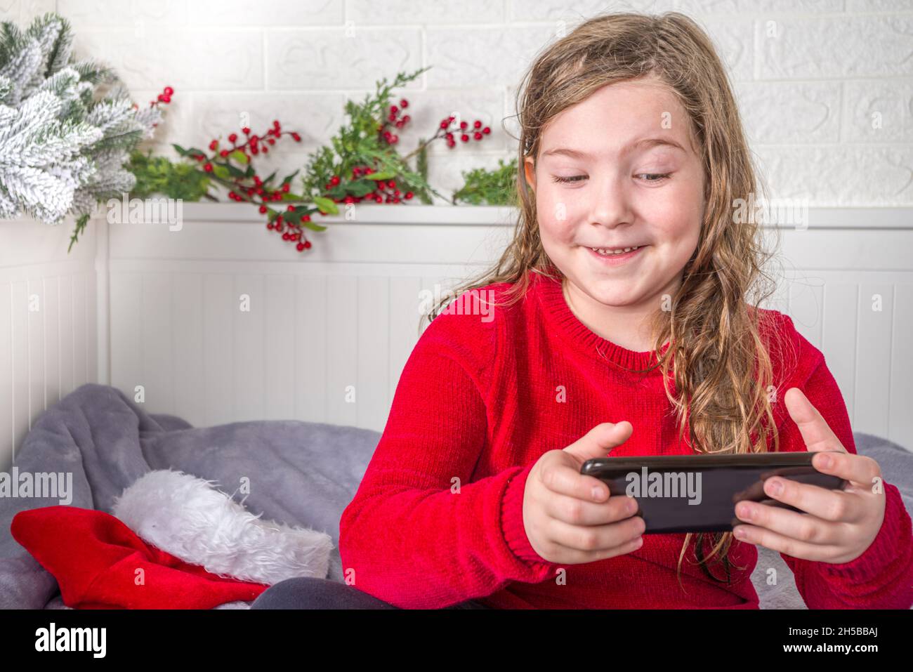 Close up photo of positive kid girl with santa claus hat and red ...