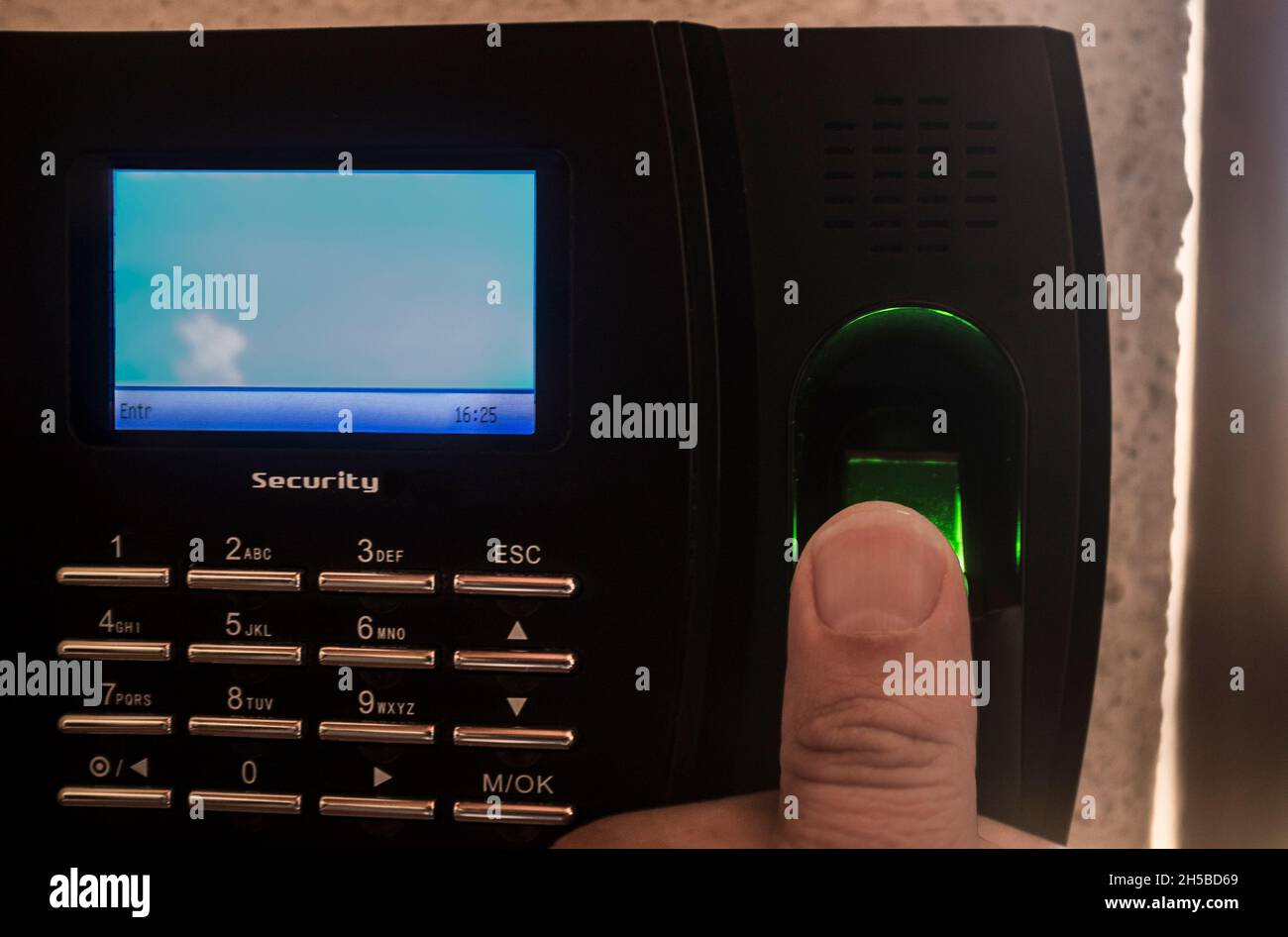 Employee doing check in on fingerprint attendance machine. Selective focus Stock Photo