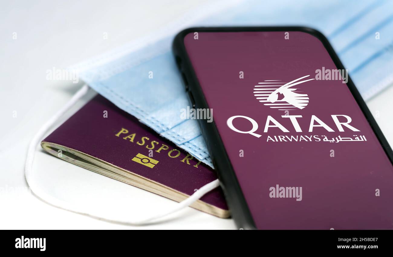 Doha, Qatar, October 2021: phone with the Qatar Airways app on the screen over a surgical mask and a passport. ITA Airways is the new Italian flag car Stock Photo