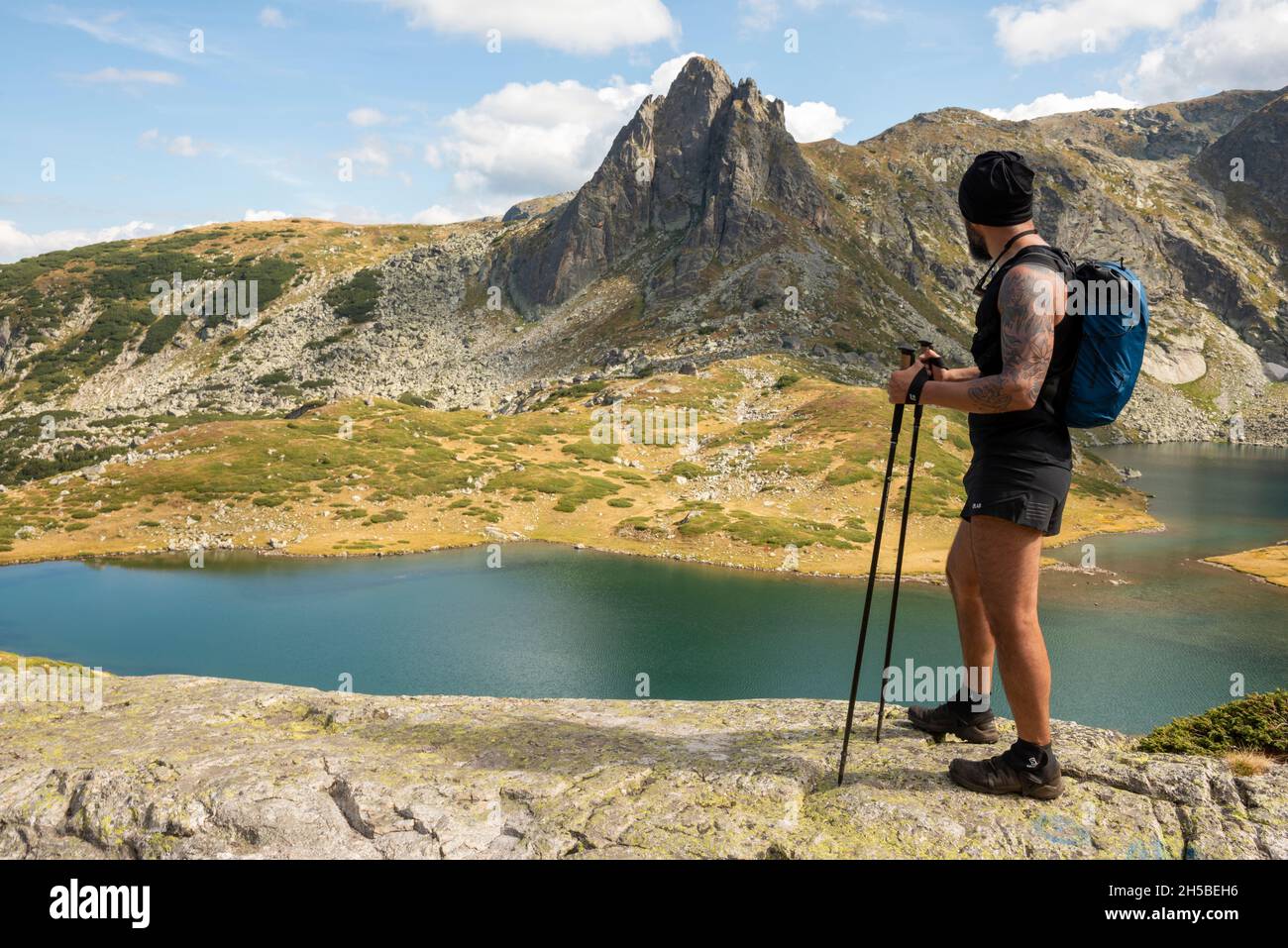 mountain hiking, tattooed hiker, trekking, hiking, Haramiyata Peak, Black Peak, glacial lake, Twin Lake, Seven Rila Lakes, Rila Mountain, Bulgaria Stock Photo