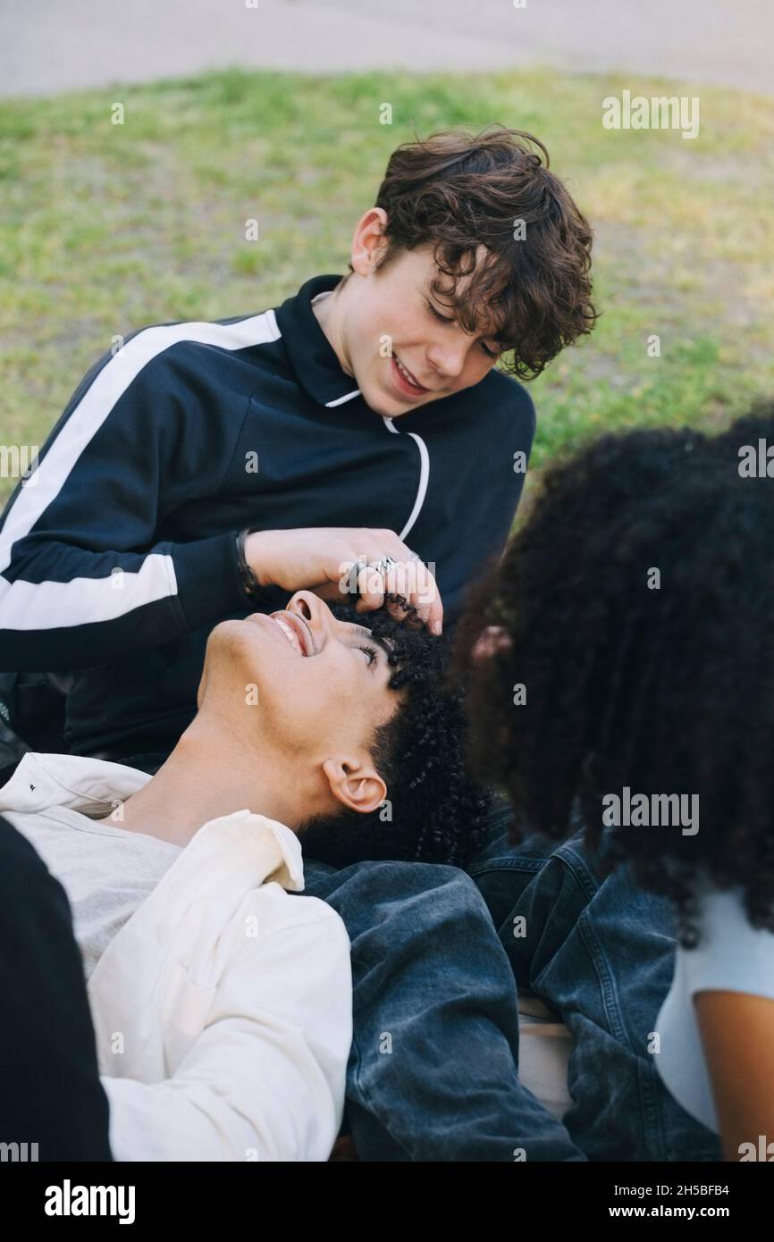 Teenage boys spending leisure time with female friend in park Stock Photo