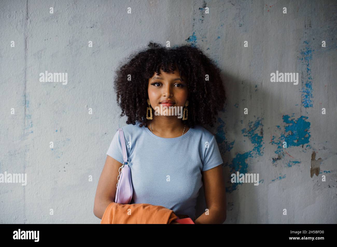 Portrait of teenage girl against wall Stock Photo