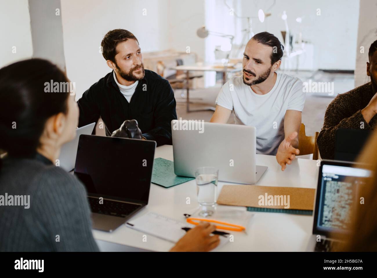 Business people brainstorming with laptop in meeting at office Stock ...