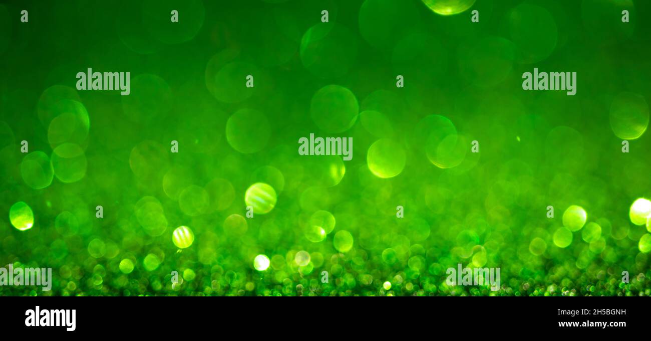 Green Christmas lights background, banner design. Shiny glowing surface with bokeh, abstract