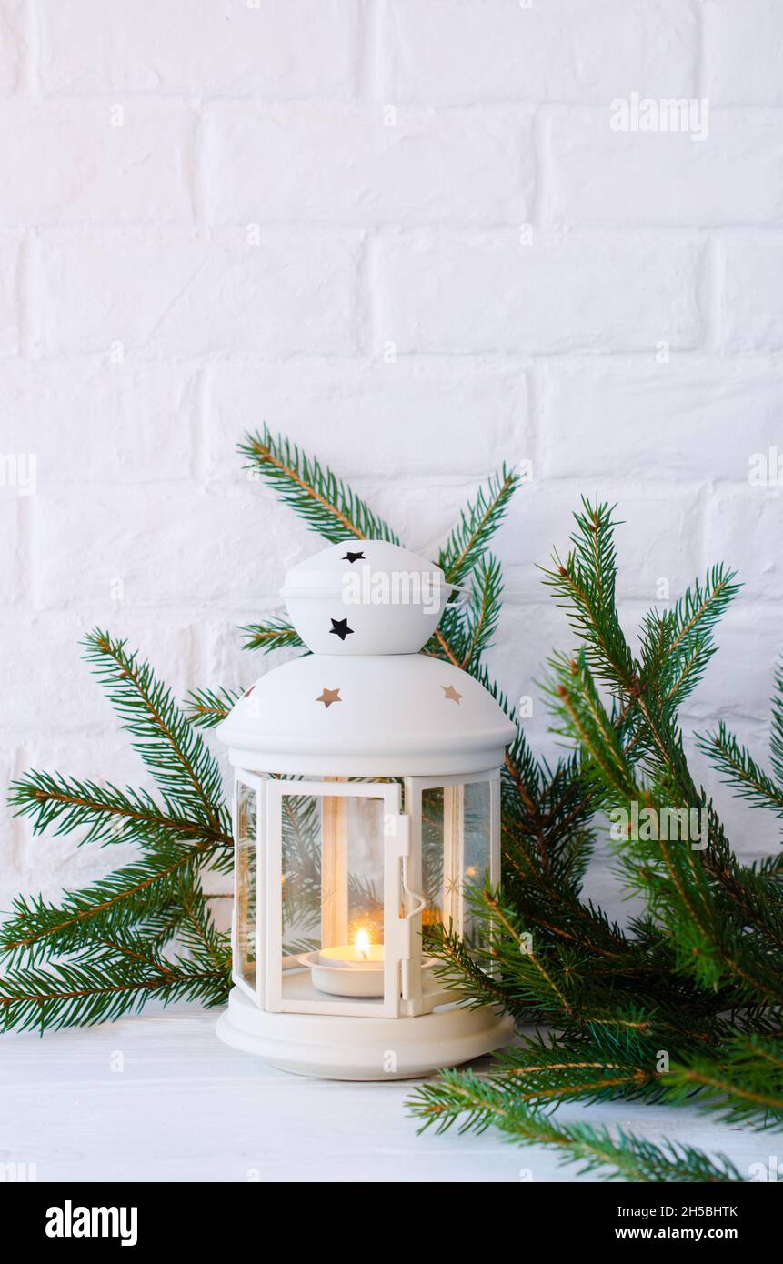 Scandinavian home decor. White lantern and fir branches. Stock Photo