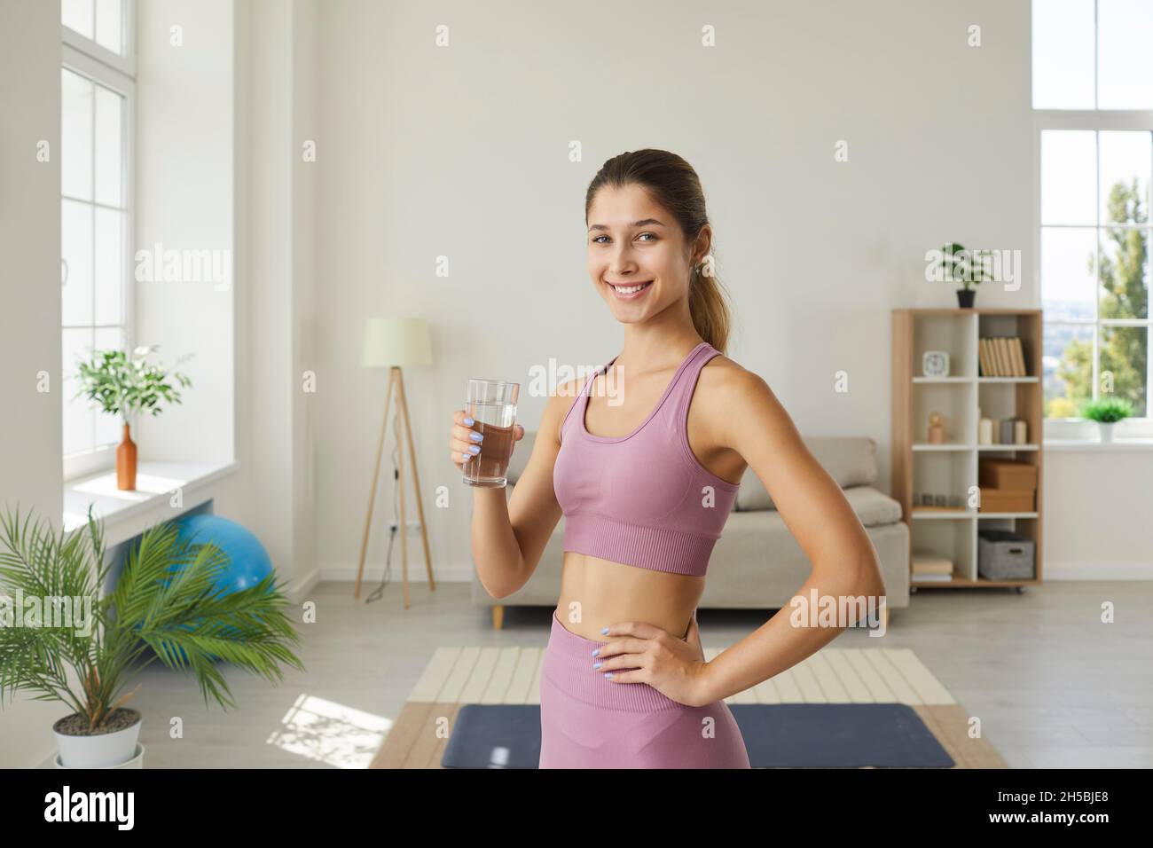 Beautiful woman drinks clean water to stay hydrated and lead a healthy lifestyle Stock Photo