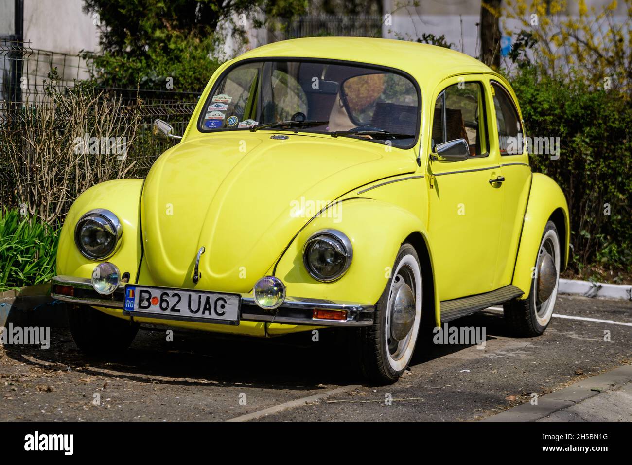 Bucharest, Romania, 2 April 2021 Old retro yellow Volkswagen Beetle classic car parked a street in a sunny spring day Stock Photo