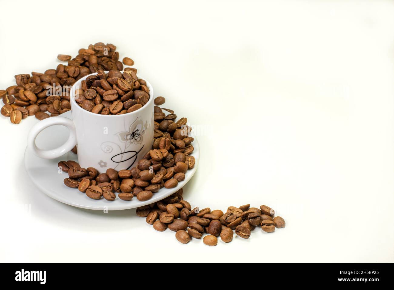 coffee grains in cup and table top on white table Stock Photo