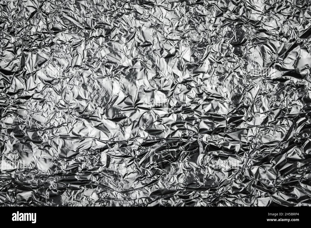 metallic crumpled aluminium foil textured background chrome tinfoil abstract Stock Photo