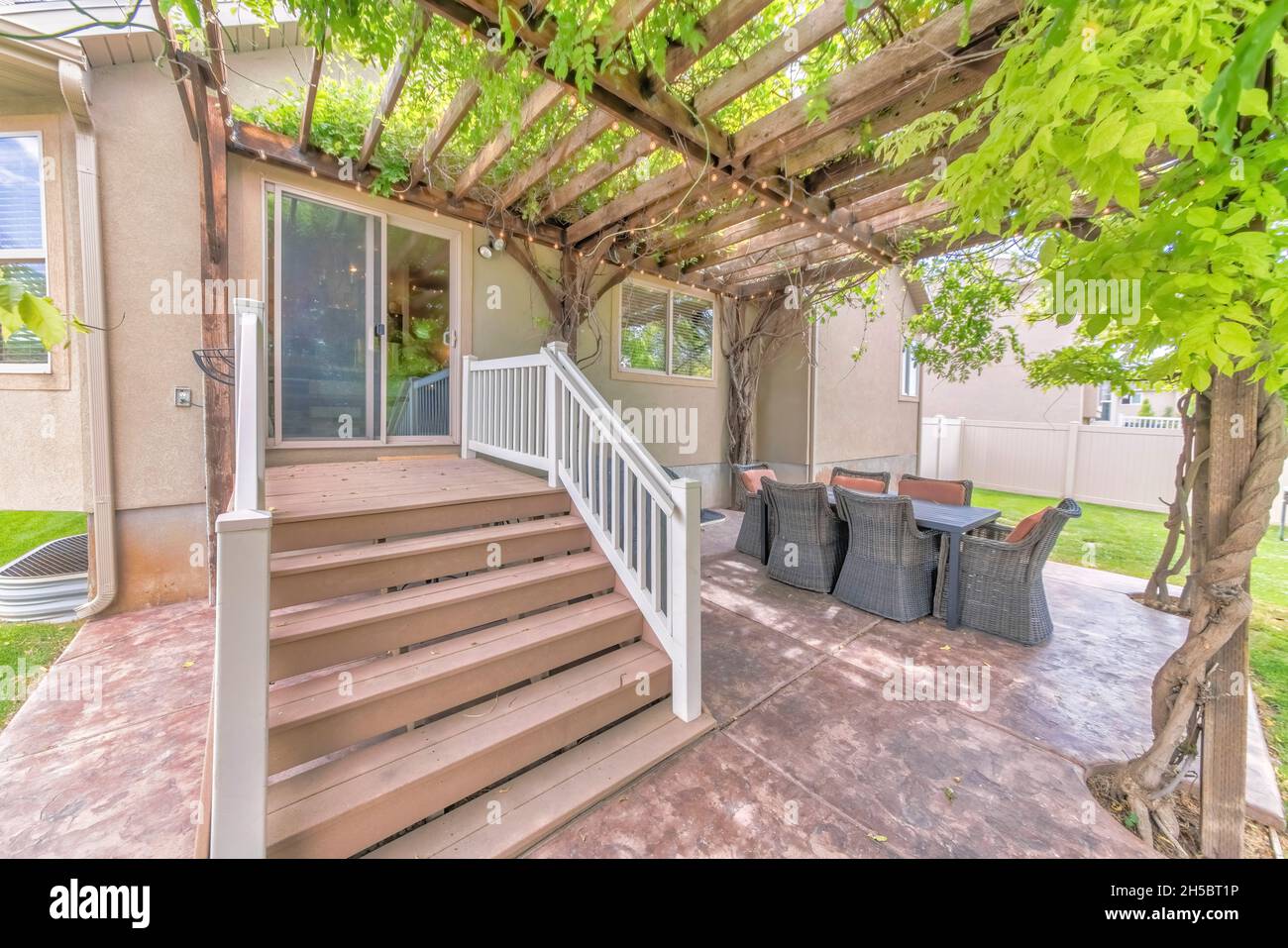 Outdoor patio with wooden pergola roof with vines and string lights Stock Photo Alamy