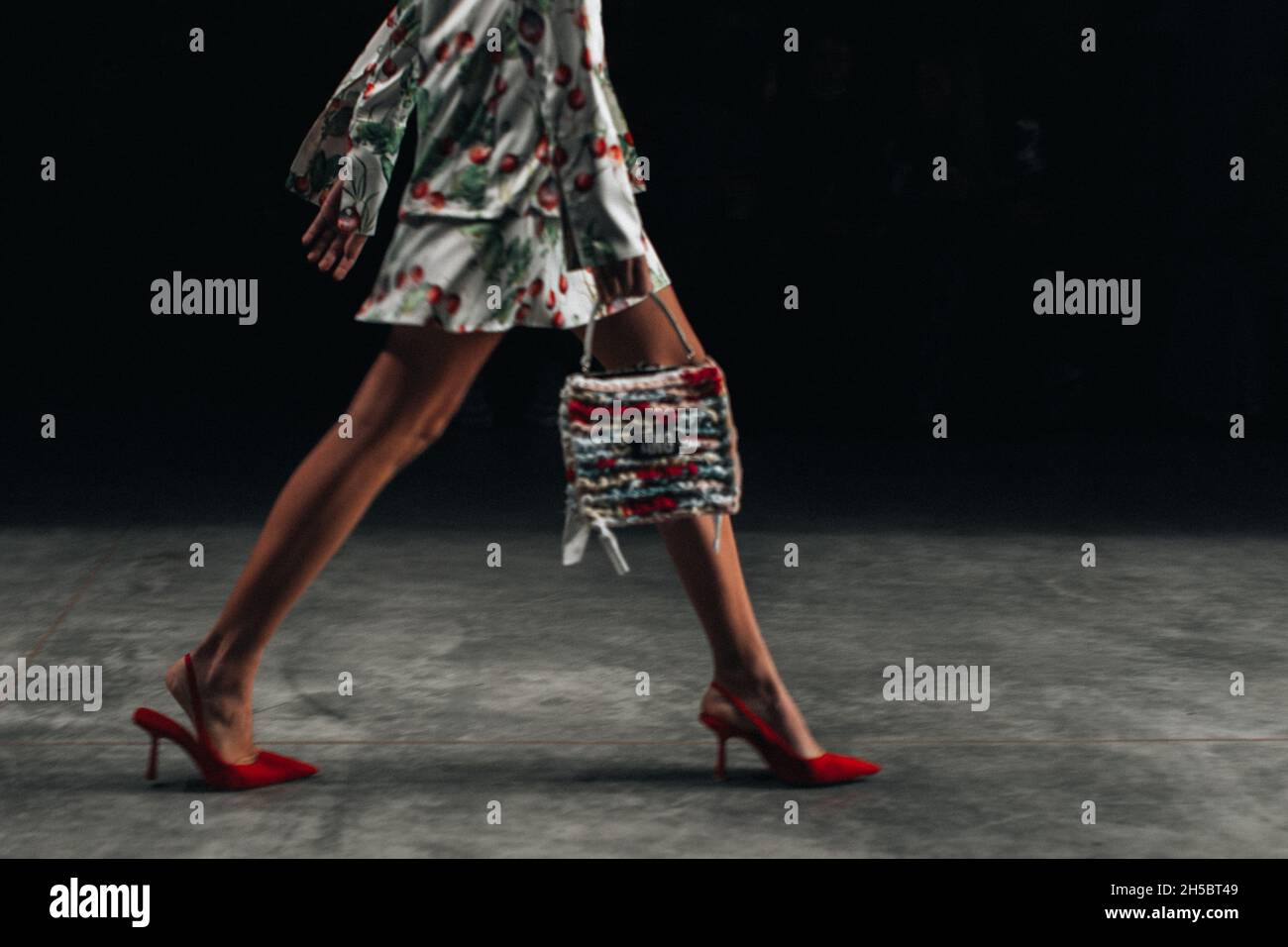 Fashion model in red high heels walking catwalk fashion show Stock Photo