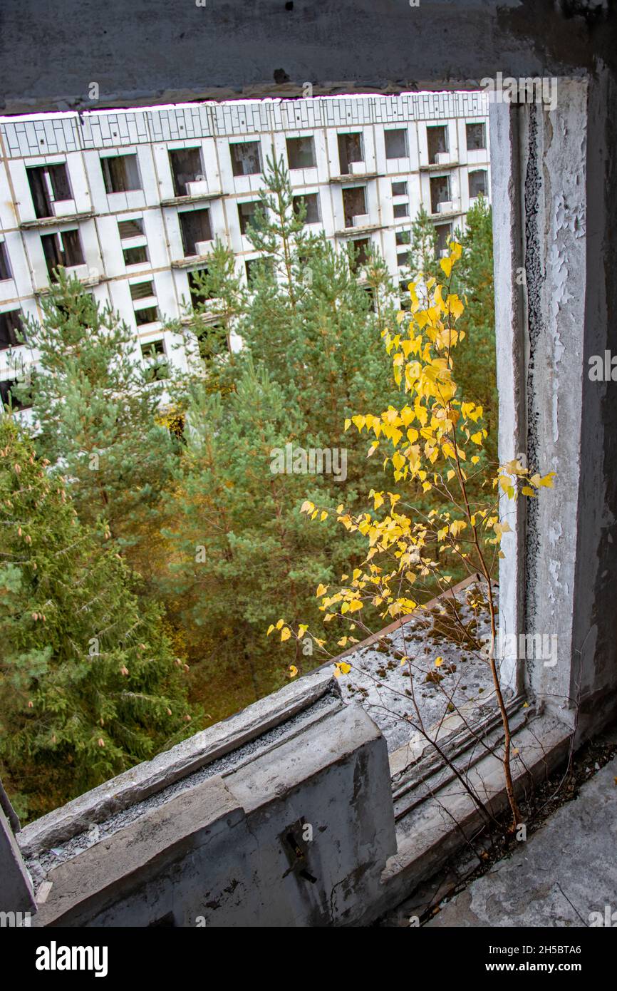 View through the hole for a balcony in a damaged abandoned panel house. Stock Photo