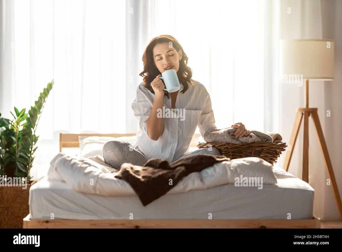 Happy young woman enjoying sunny morning on the bed Stock Photo - Alamy