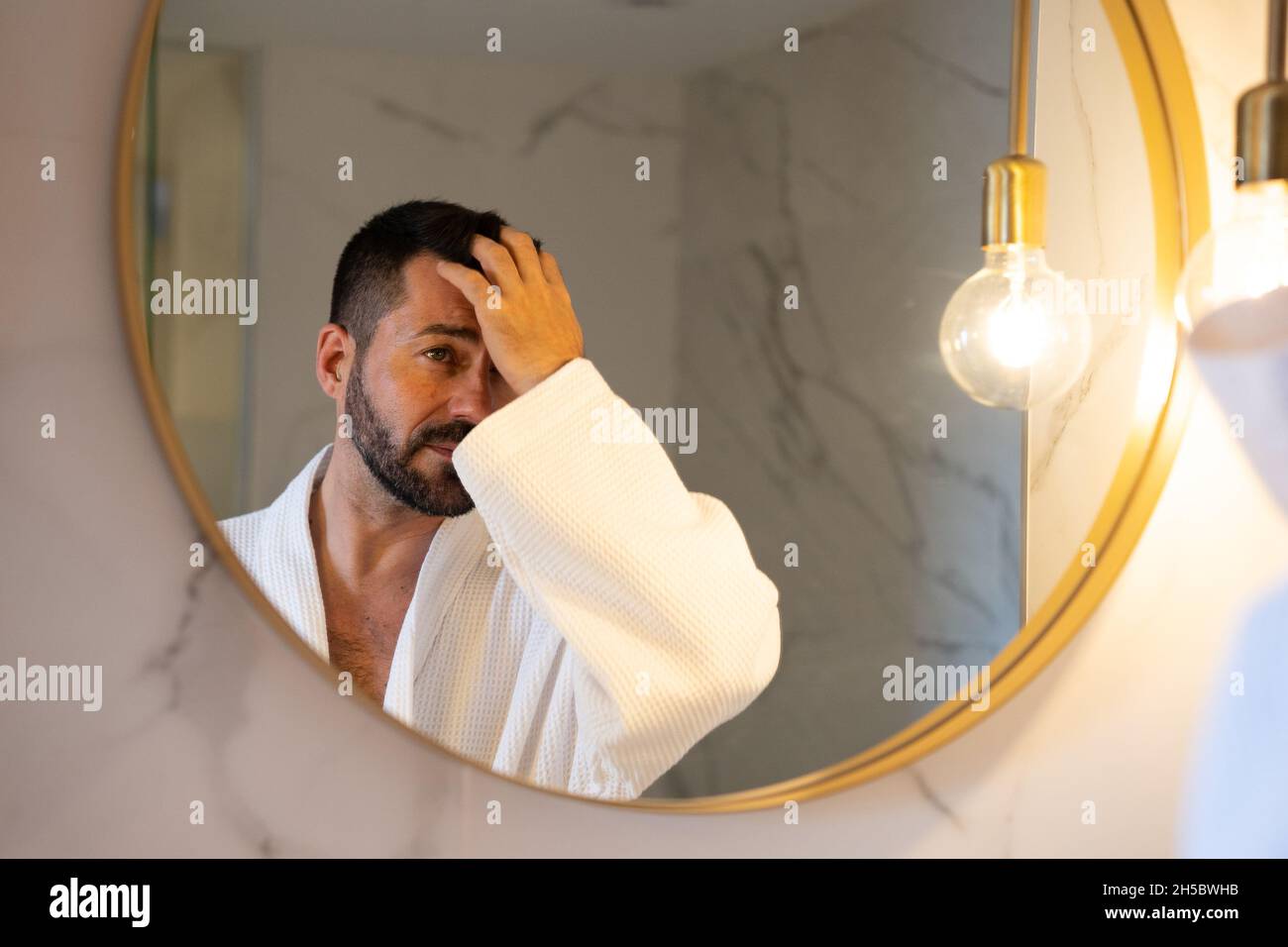 man in bathrobe looking at himself in the mirror Stock Photo - Alamy
