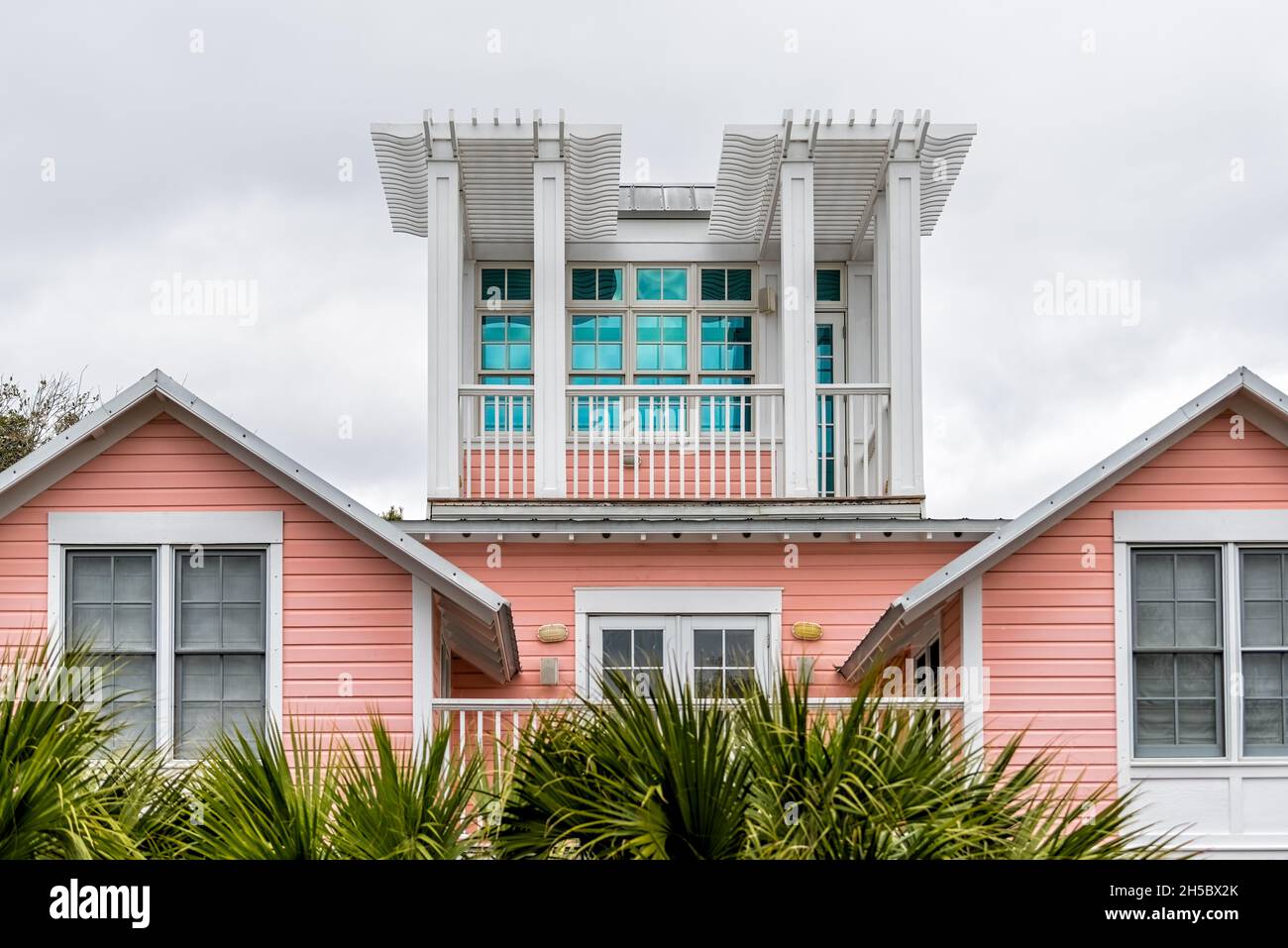 Wooden house tower new urbanism pastel pink architecture design by beach ocean in Seaside, Florida view on cloudy day Stock Photo