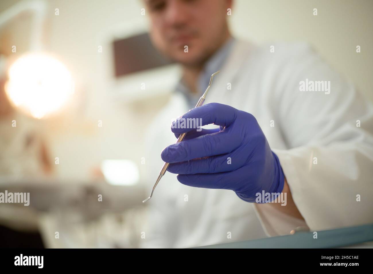Tools in the hands of the dentist. Blue gloves Stock Photo - Alamy