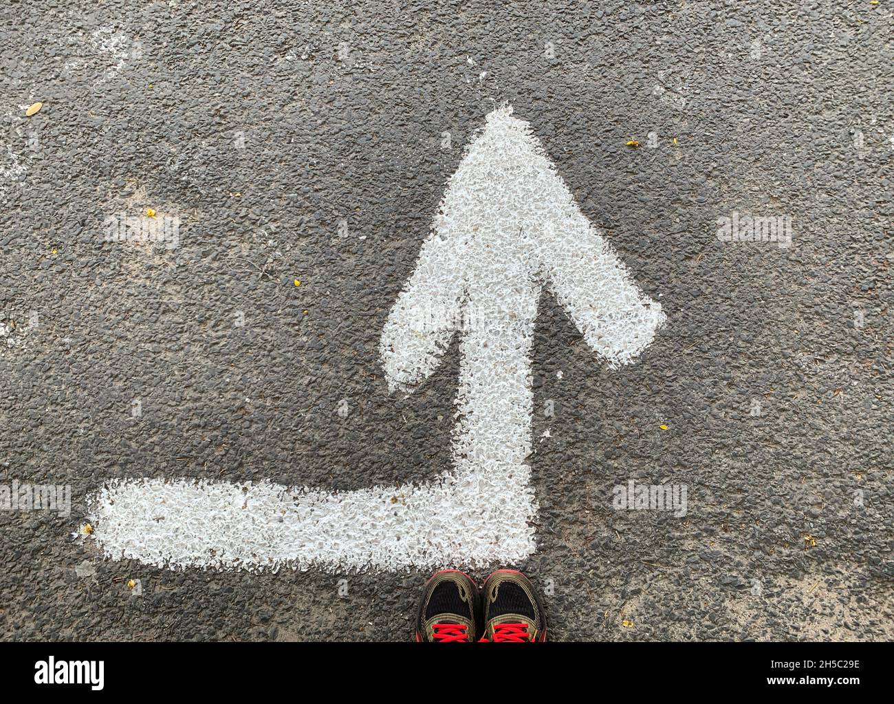 Runner standing on road by a left turn arrow, New Delhi, India Stock Photo