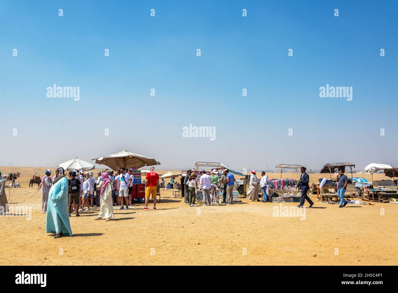 GIZA, EGYPT - JULY 14, 2021: Tourists and vendors near the Great Pyramid in Giza, Egypt Stock Photo