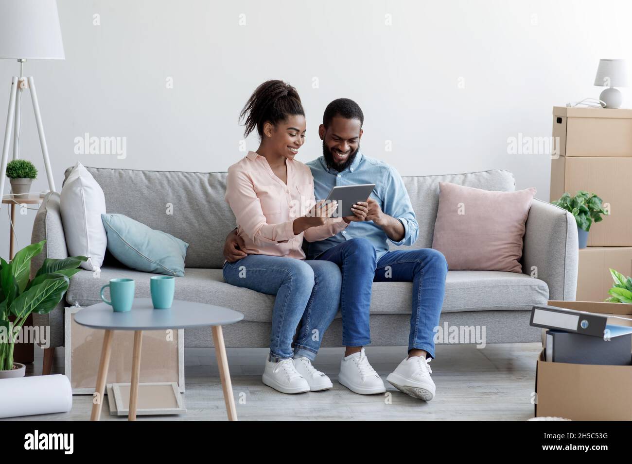 Cheerful smiling young african american husband and wife sitting on ...