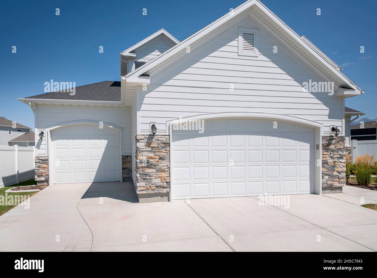 Three car garage exterior with two white garage doors with arched door