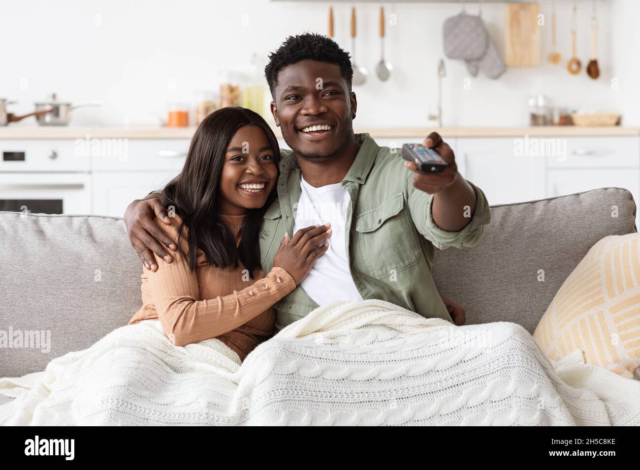 Joyful african american couple watching TV together at home Stock Photo ...