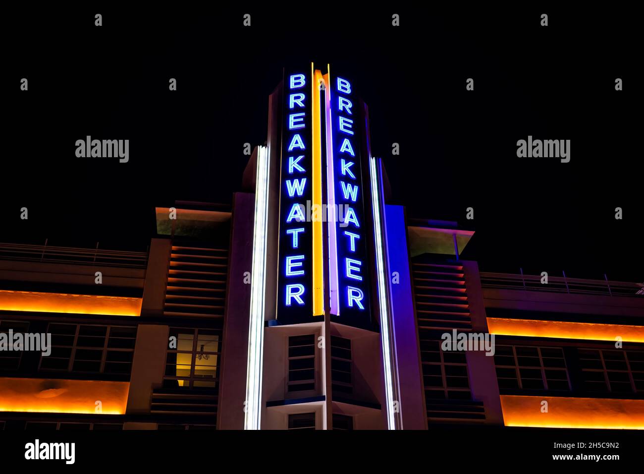 Miami Beach, USA - January 20, 2021: Looking up low angle view on art deco district at night with neon blue light sign of Breakwater Hotel facade in S Stock Photo