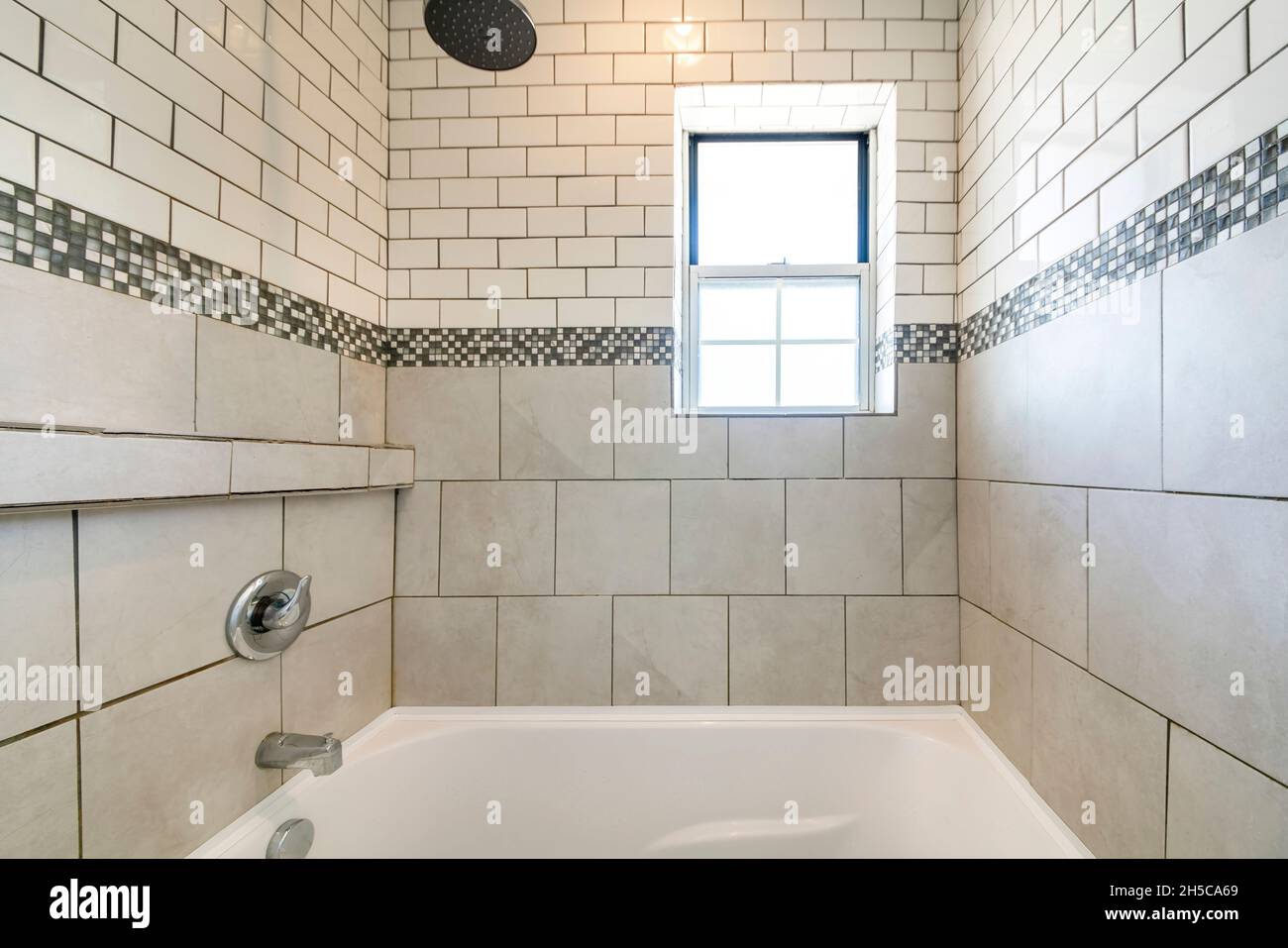 Alcove bathtub shower combo with ceramic and subway tiles wall with