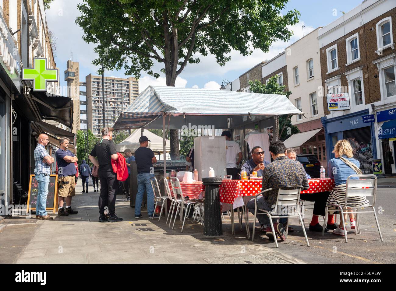 People eating outside on Golborne Road in West London, England. Photo: SMP NEWS Stock Photo