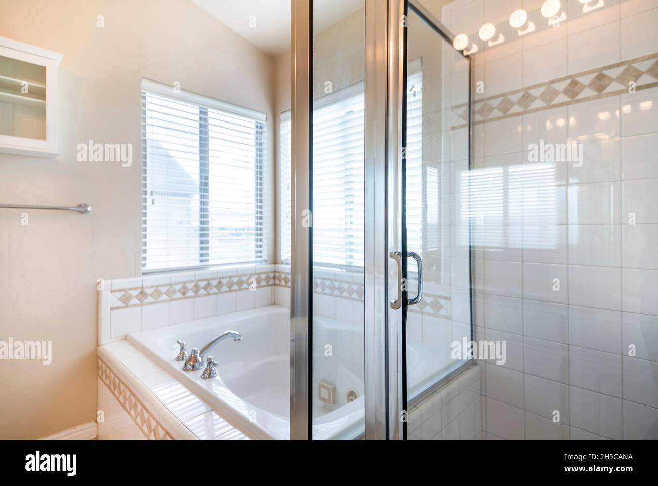 Bathroom interior with bathtub and shower stall with ceramic tiles
