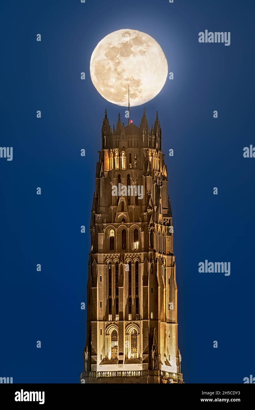 Blue Moon Over The Riverside Church NYC - Super moon rises and lines up above the gothic architecture style structure of The Riverside Church in upper Stock Photo