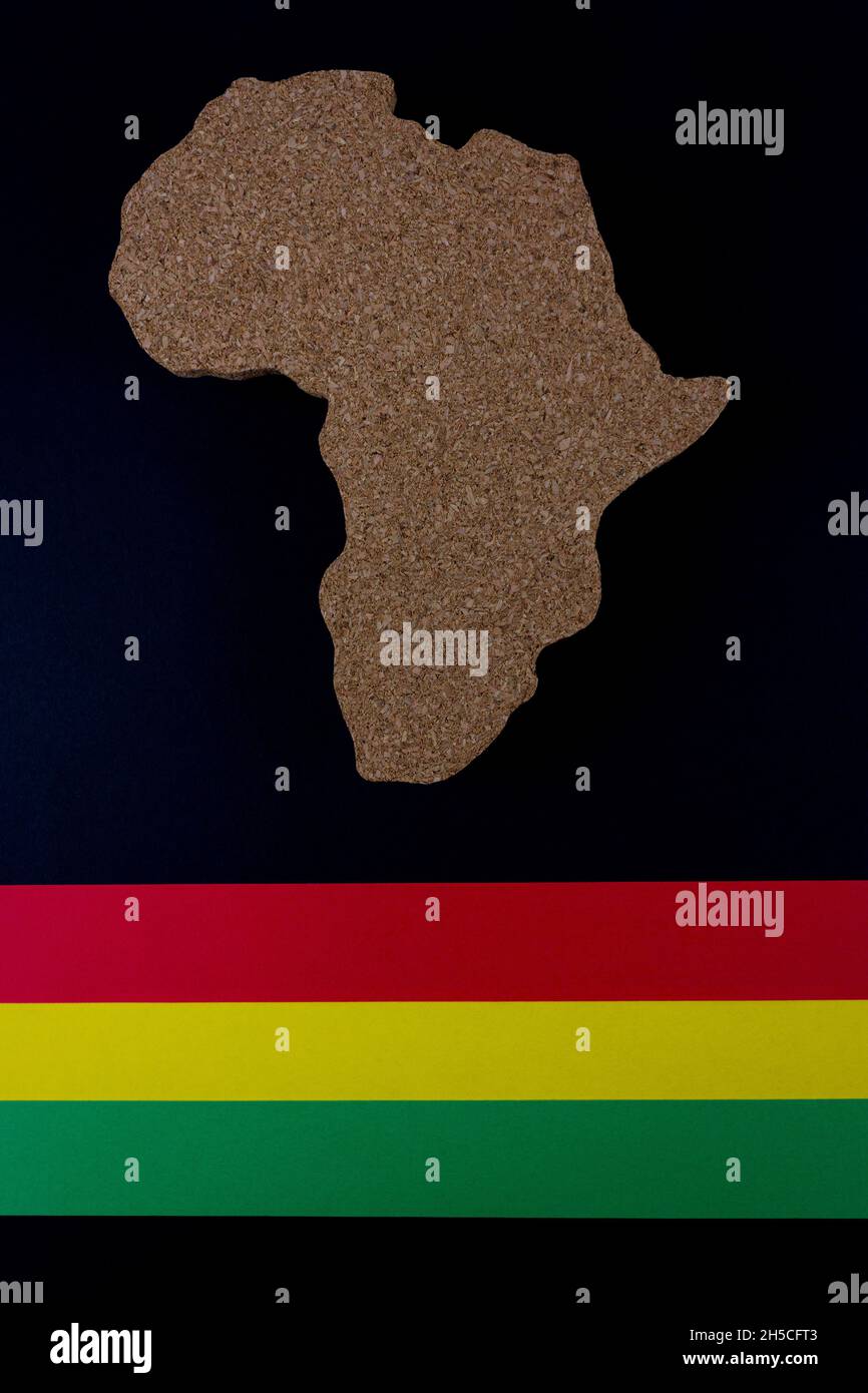 Black History Month concept. Africa Continent shape with traditional red, yellow and green color bar. Space for your text. Flat lay. Stock Photo