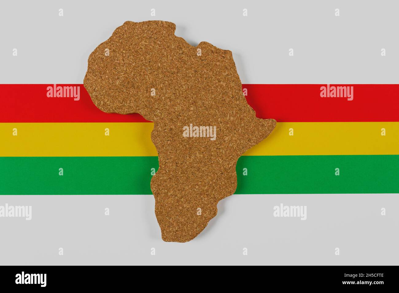 Black History Month concept. Africa Continent shape with traditional red, yellow and green color bar on white background. Space for your text. Flat la Stock Photo