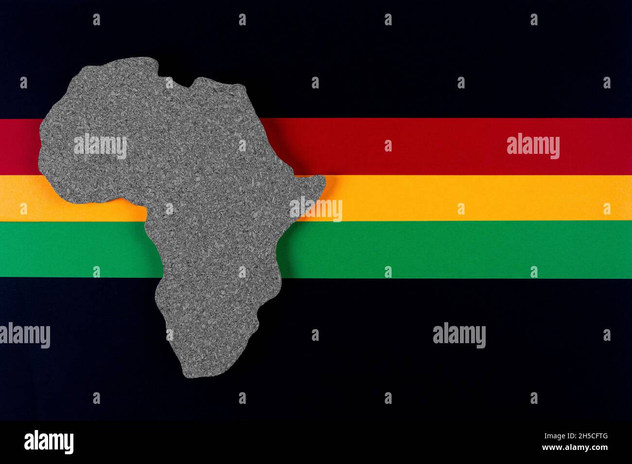 Black History Month concept. Africa Continent shape with traditional red, yellow and green color bar. Space for your text. Flat lay. Stock Photo
