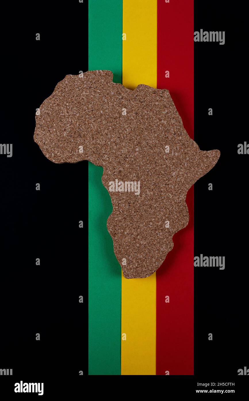 Black History Month concept. Africa Continent shape with traditional red, yellow and green color bar. Space for your text. Flat lay. Vertical photo. Stock Photo