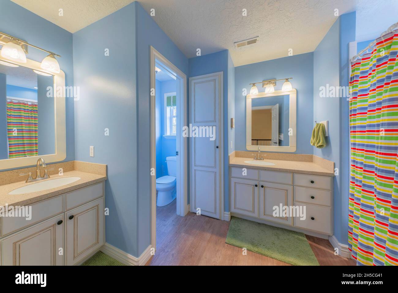 Master bathroom with light blue interior and two vanity sinks Stock