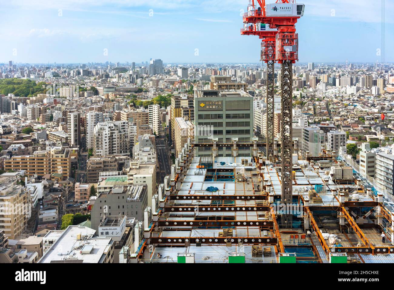 tokyo, japan - may 03 2019: Bunkyo Garden Gate Tower under construction with elevated cranes on top of the skyscraper and workers walking on the load- Stock Photo